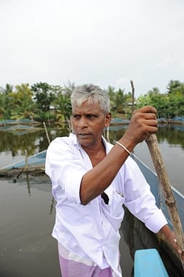 Guiding a canoe through a fish farm at Seeduwa near Negombo.  Photo: IWMI/Saaliya Thilakarathna