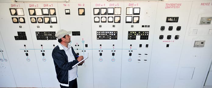 An engineer checks machinery at a water pumping station in northern Tajikistan, near the border with Uzbekistan. Photo: Neil Palmer for IWMI.