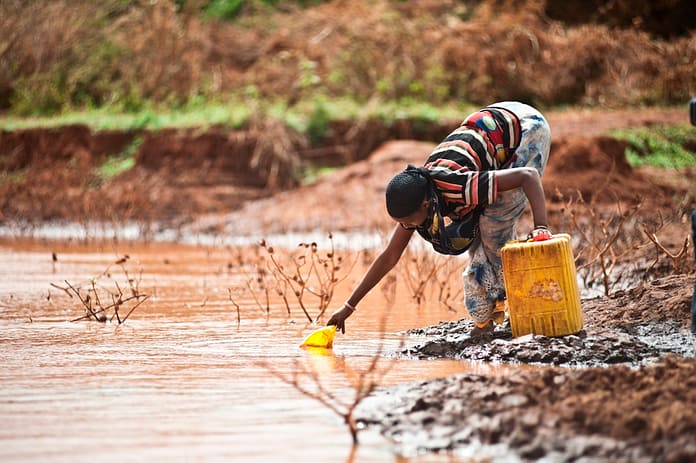 A woman collects water from a pond in Tuka village