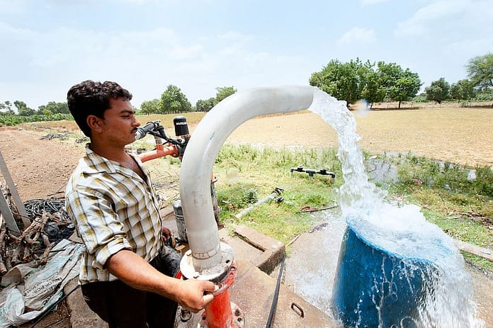 Man operating a electric motor pump in his plantation. Photo: Hamish John Appleby / IWMI