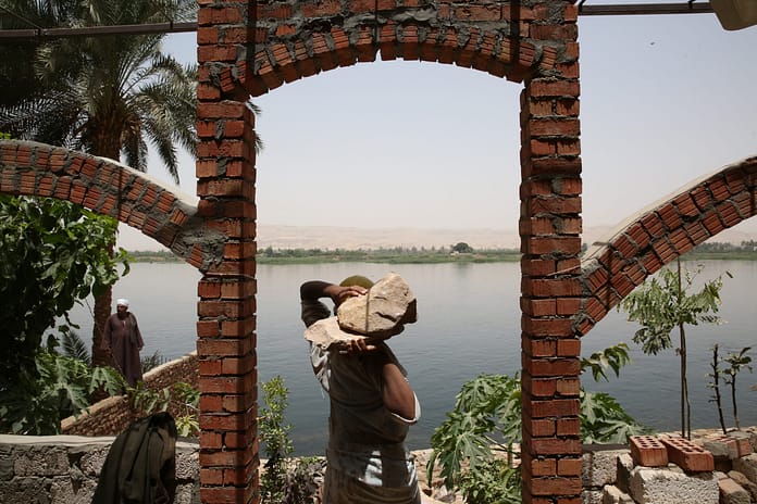 Construction workers build stronger riverbanks along the Nile River to protect it from erosion. Dominic Chavez/World Bank.