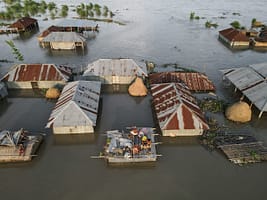 A family takes shelter on the roof of their house in Kurigram District, Bangladesh. Photo: Muhammad Amdad Hossain / Climate Visuals