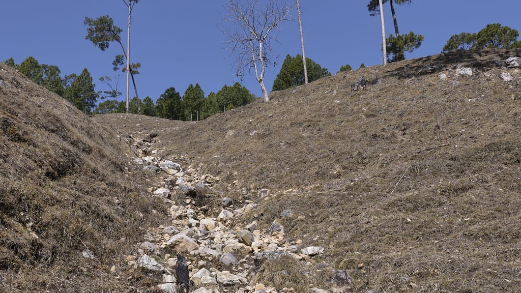 An arid hillside north of Chhatiwan lake. Gravel, fallen trunks and soil carried downslope during heavy rains accumulate in the lake, gradually reducing water depth and storage capacity over time. Photo: Sunny Deshar/IWMI