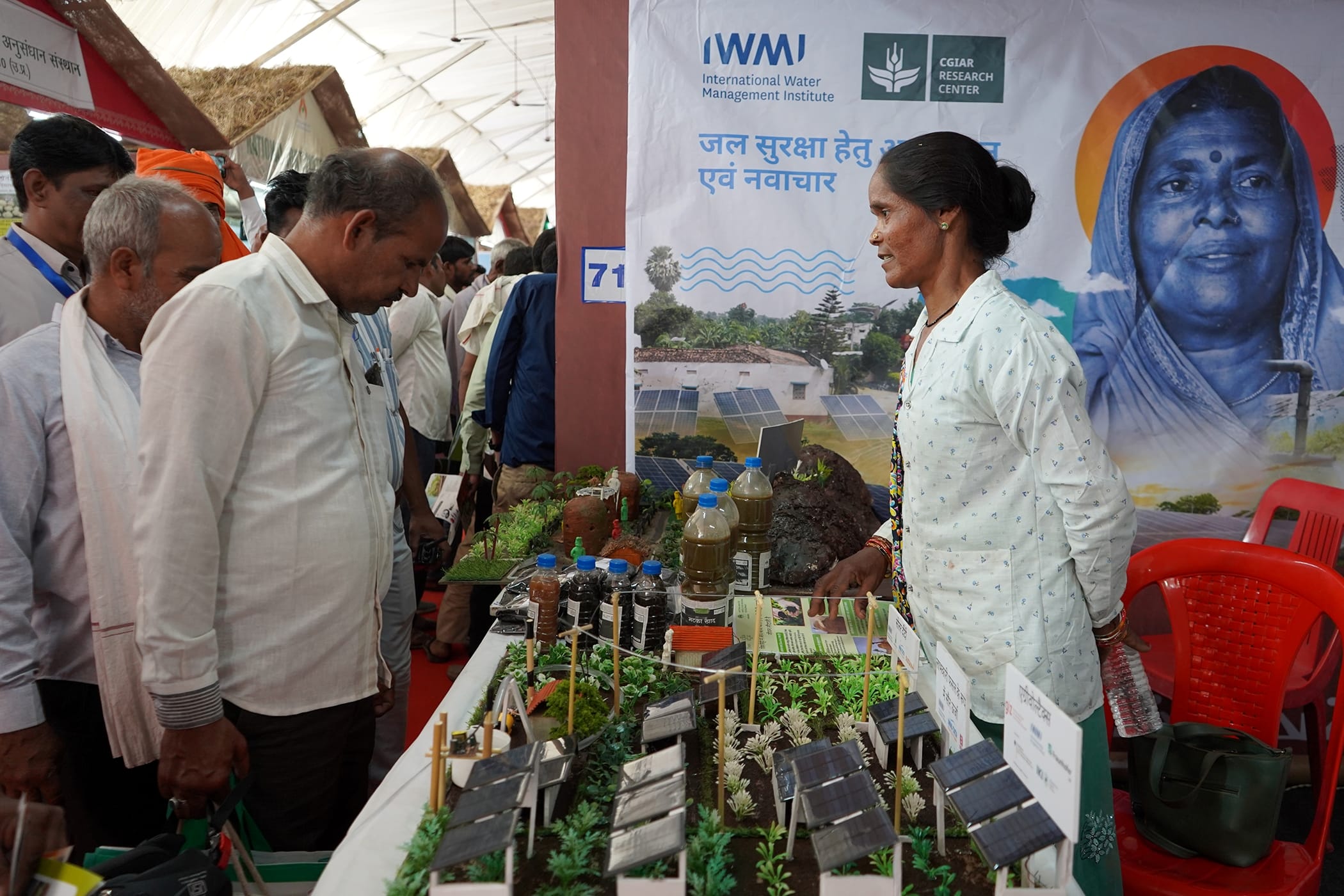 Farmer Savni Kulaste, explains agro-homestead farming, solar irrigation models, and biochar practices to visitors at the IWMI stall during the Unnat Krishi Mahotsav 2026 in Raisen, Madhya Pradesh, India. Photo: IWMI