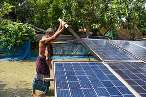 Mohammed Nurul Islam, a 60-year-old farmer and micro Solar Irrigation Pump (SIP) user, sets up his portable solar pump in Goalia village, Barishal, Bangladesh. The micro SIP, provided to a farmers' group by the Bangladesh Rice Research Institute (BRRI), aims to reduce reliance on diesel pumps and improve irrigation access for local farmers. Photo: Tanmoy Bhaduri/IWMI