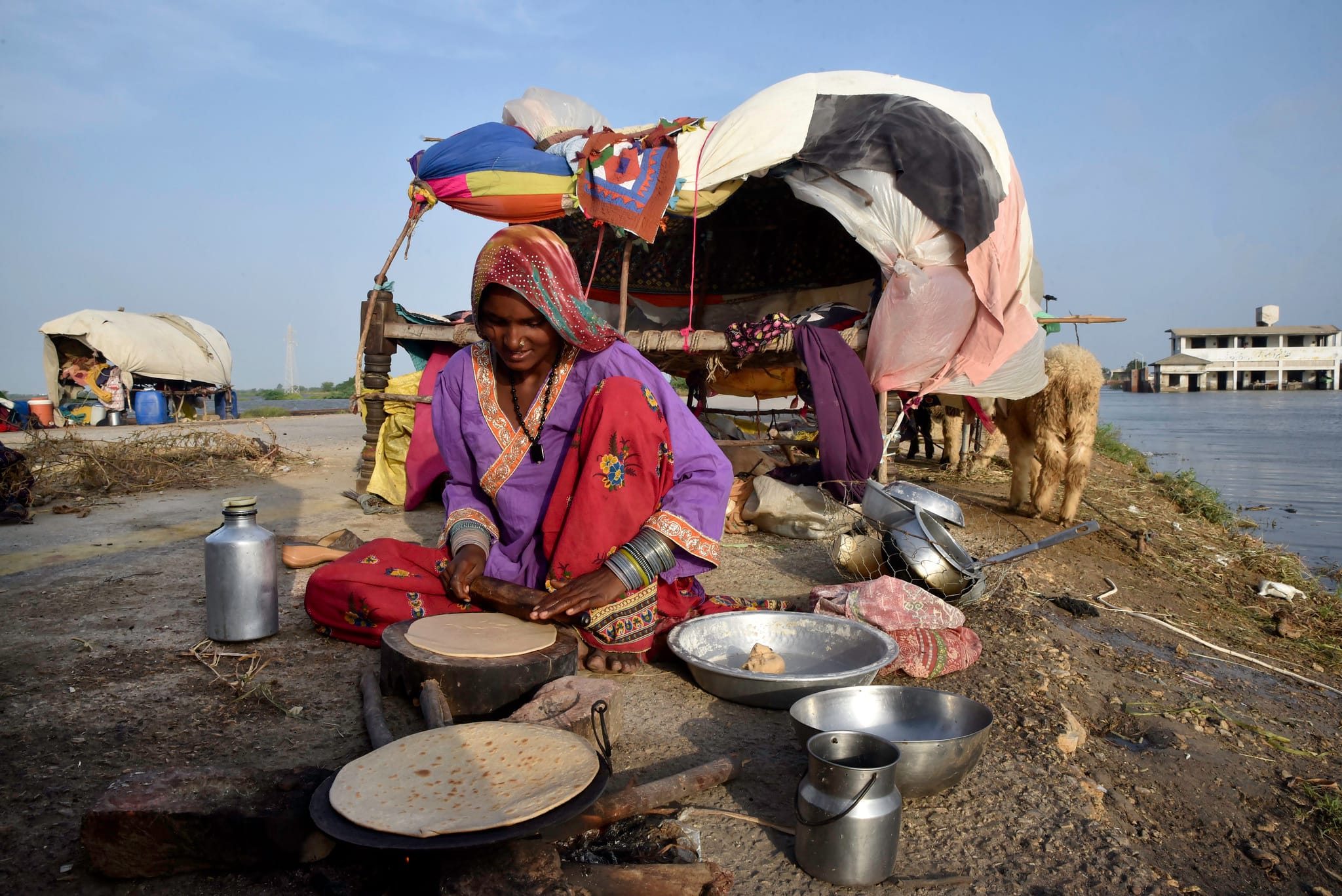 A woman cooks bread outside her tent in flood-affected Pakistan. Photo: Abdul Majeed/European Union