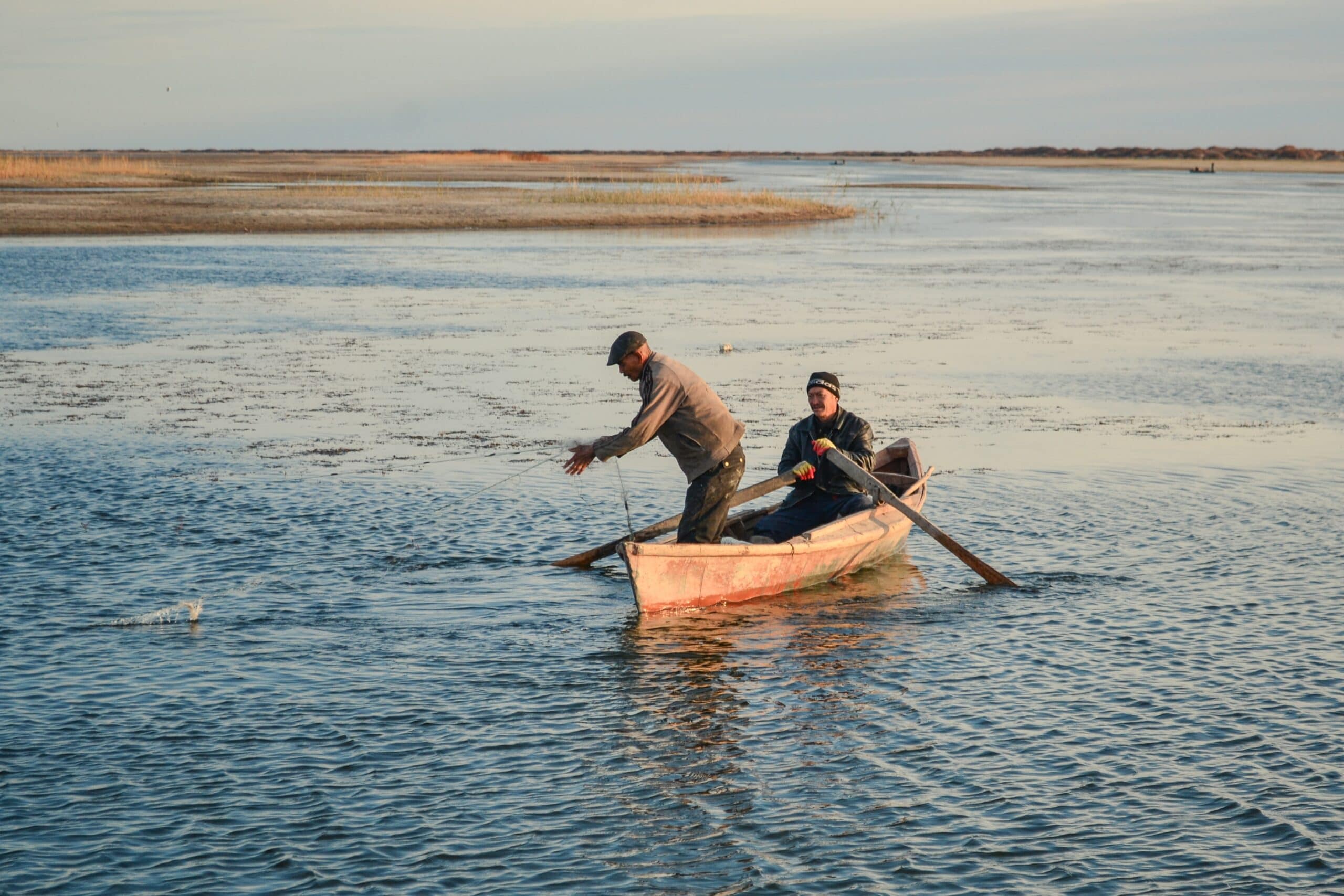 Two men fish in a small lake formed by a dam near Moynaq, after the retreat of the Aral Sea in Kazakhstan. Photo: The Road Provides/Shutterstock