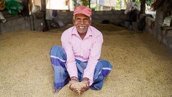 Thampi Dhanapalasingham, a farmer from Nallur, at home with his paddy harvest. Photo: Pradeep Liyanage/IWMI
