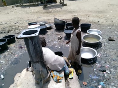Children waiting for borehole to be repaired to fetch water in Dong, Demsa LGA Adamawa state. Photo: Mark Polycarp / IWMI