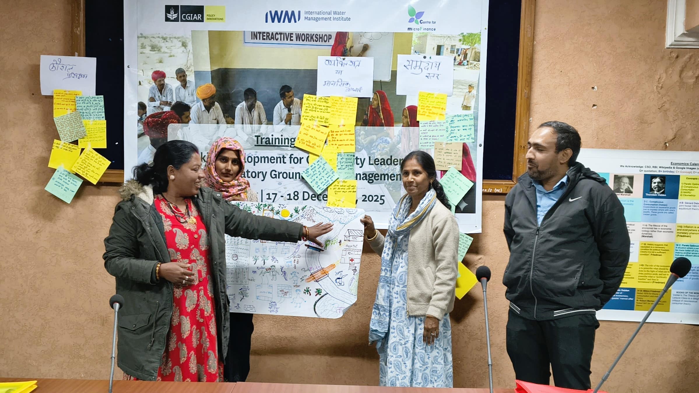 Kiran, Parvati and Asha from Civil Society Organization Rajeevika, along with Praveen from the Department of Watershed Development and Soil Conservation in Rajasthan, explain their mapping of a local village's water flows, agriculture and community spaces. Photo: Anurag Banerjee/IWMI