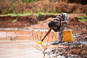 A woman collects water from a pond in Tuka village