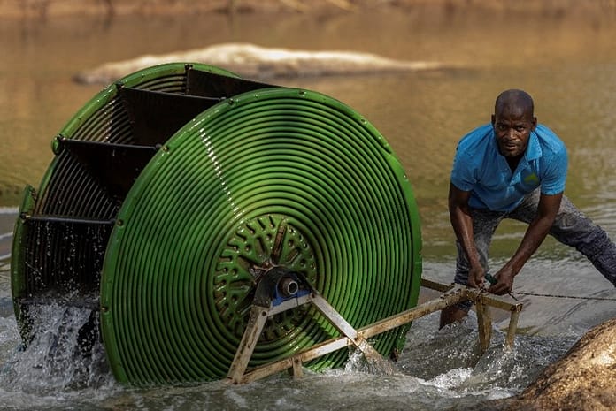 A farmer in Malawi installing a hydro-powered water pump. Photo: GIZ