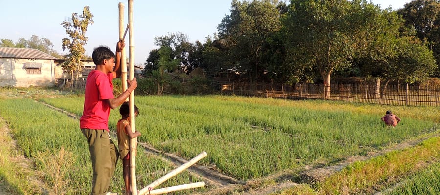 A girl learns to operate a treadle water pump in Saptari, Eastern Terai, Nepal, with her father