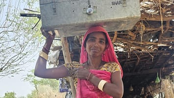 A member of a water user group carrying their meeting and account records in Dingar village, India. Photo: Suchiradipta Bhattacharjee/IWMI