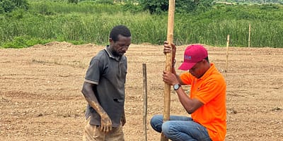 Preparing to plant an oil palm seedling on a reclaimed post-mined site. Photo: Eric Nartey / IWMI