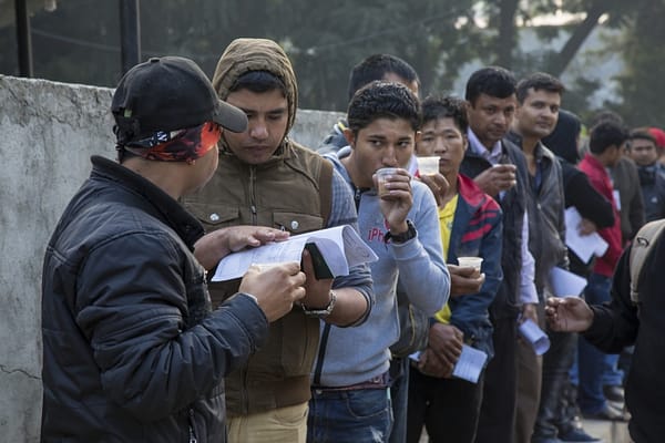 Prospective migrants queue to process the required paperwork outside of Tribhuvan International Airport, Kathmandu.  Some governments actively encourage and facilitate migration for the remittances it brings, but the money earnt abroad is often insufficient to lift families permanently out of poverty. Photo: Sharad Maharjan