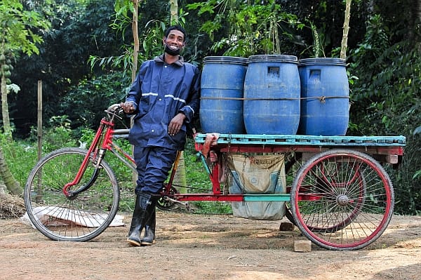 Dhakar, Bangladesh. A Pit latrine emptier collects and transports human waste to a site to be processed into fertilizer. Waste collection like this, whether by bicycle or tanker truck, tends to be the preserve of the private sector in most African and Asian cities. It creates jobs, but handling and safe disposal of the waste once collected remains a challenge. Photo: Neil Palmer