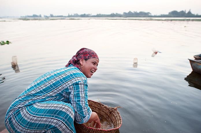 Woman washing wheat in a river in Egypt. Photo: Hamish John Appleby