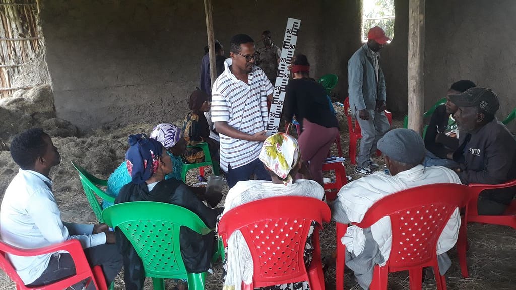 An IWMI research assistant explains how to measure river water levels to citizen scientists in South Sodo District of Central Ethiopia. Photo: Tilaye Worku / IWMI