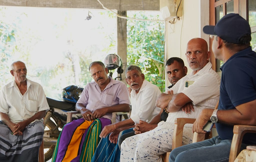 Farmers from Kurunegala, Sri Lanka, H. M. Somaratne, D. M. Ruwan Anuruddha, M. H. A. Sarath Kumara and H. U. D. Herath speaking with Niranga Alahacoon, a regional researcher at the International Water Management Institute (IWMI), on March 6, 2026. Photo: Lahiru Madushanka/IWMI