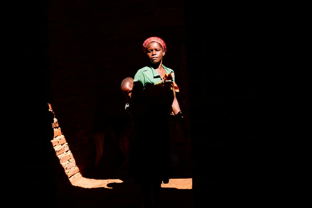 Sipiue Paulo stands with her son inside their home, which was partially destroyed by Cyclone Idai in 2019. One of the worst tropical storms to hit Southern Africa, the cyclone tore through Mozambique, Malawi and Zimbabwe, causing more than $2 billion in damage. Photo: Isabel Corthier/International Potato Center