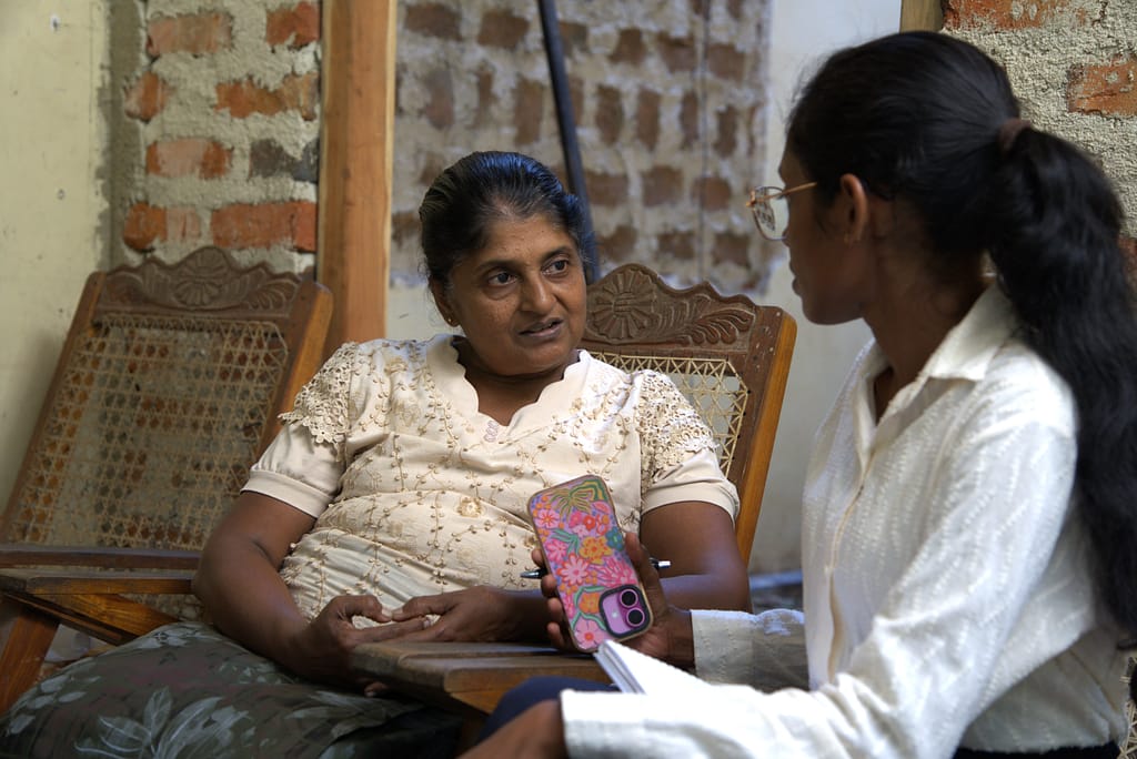 International Water Management Institute Assistant Research Officer Kalpani Jayamini interviewing Sardha Dayanshani, Aruna Farmer Organization secretary, on her experiences with the high-quality seeds and weather advisories in Kurunegala, Sri Lanka, on March 6, 2026. Photo: Lahiru Madushanka/IWMI
