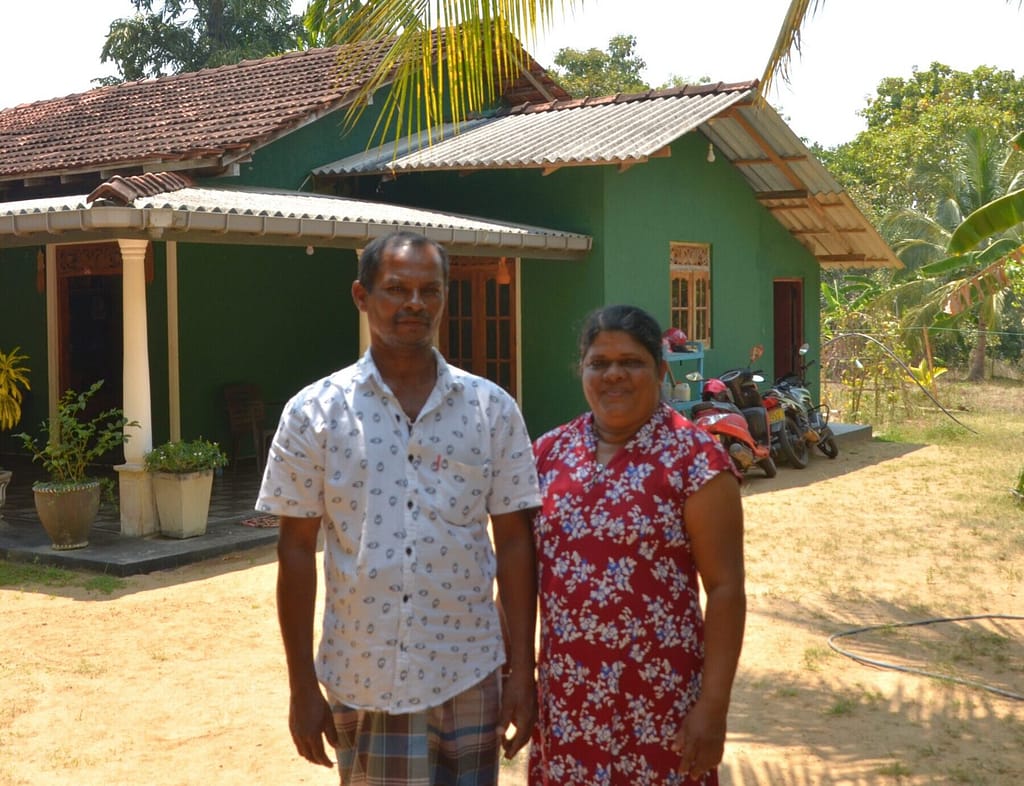 MNM Ratnasiri Bandara and KM Swarnakumari standing in front of their home in Kurunegala, Sri Lanka, on March 6, 2026. Photo: Hasti Sadri/IWMI