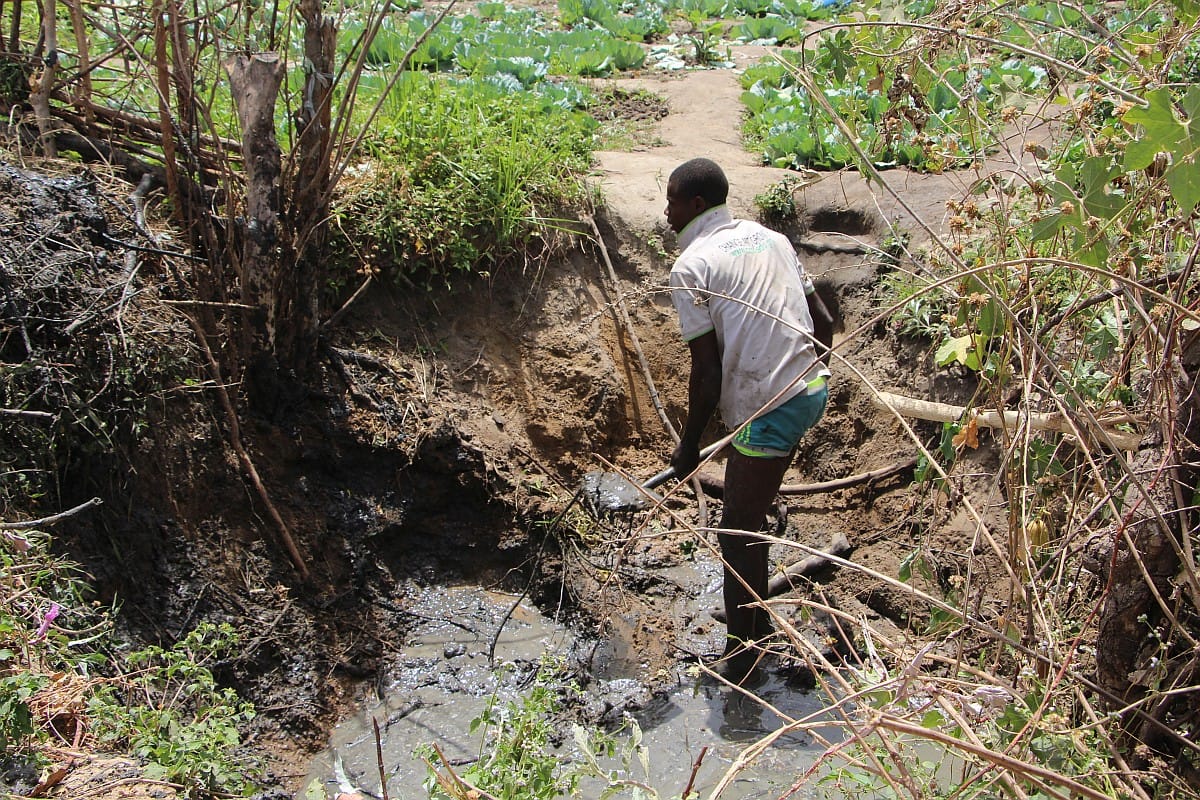 Fatawu Danyarigi desilting a dugout in Loggu. Photo: IWMI