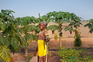 A woman farmer inspecting a sprinkler Photo credit: Hamish John Appleby / IWMI