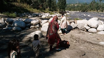 Women gather at the riverbank to wash clothes, a routine that once consumed hours each day as families relied on distant streams for their water needs. Photo: Amjad Jamal/IWMI